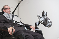 Foto von Mann im Rollstuhl mit Roboterarm und der Sondersteuerung MyEcc Pupil